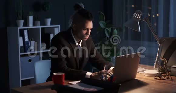 累了的商人晚上在手提电脑上做伸展运动视频的预览图