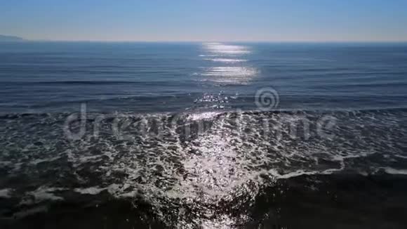 在阳光明媚的日子里飞越平静的蓝色海水视频的预览图