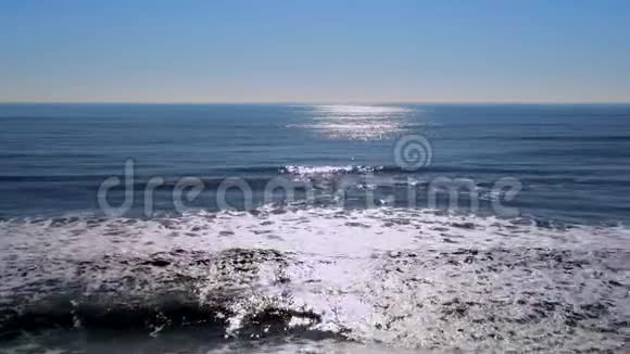 在阳光明媚的日子里飞越平静的蓝色海水视频的预览图