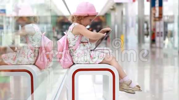 在购物中心玩平板电脑的女孩子婴儿在智能手机上使用游戏应用程序视频的预览图