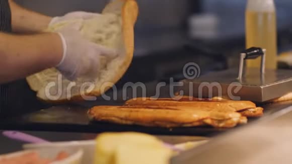 厨师把面包放在一个热金属盘上煮用来做早餐三明治视频的预览图