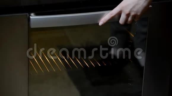 女性的手把巧克力饼放在烤箱里视频的预览图