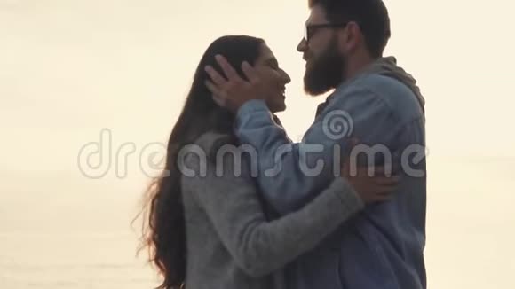 快乐的男人在额头亲吻他的女朋友在大自然中漫步在阳光下视频的预览图