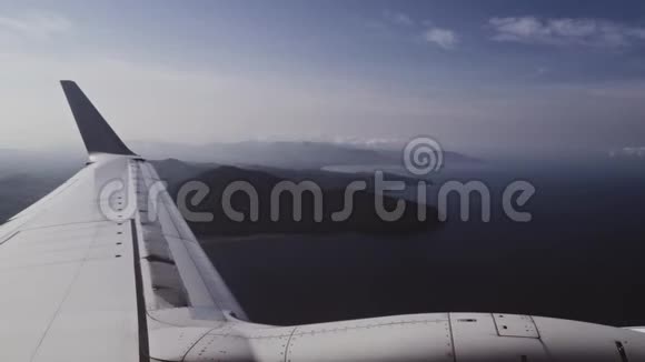飞机飞越热带岛屿上空透过飞机窗户观看视频的预览图