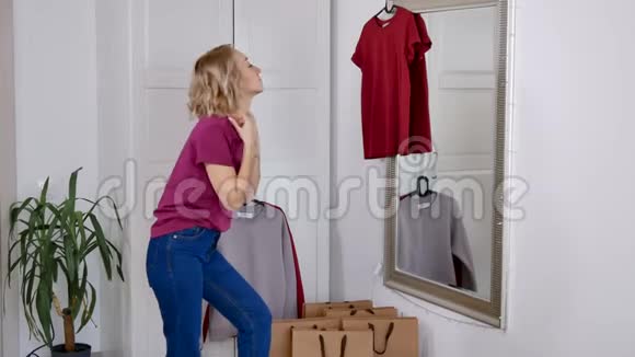 快乐的女人在家买东西后试着穿新衣服视频的预览图