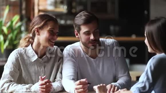 幸福的年轻夫妇客户签订保险合同握手视频的预览图