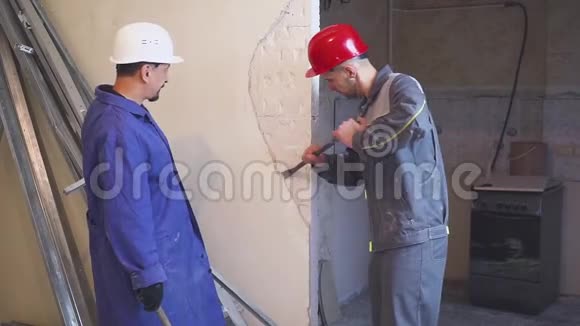 两名工人穿着防护服拆除石膏墙视频的预览图