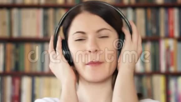 快乐女大学生图书馆用大无线耳机听音乐视频的预览图