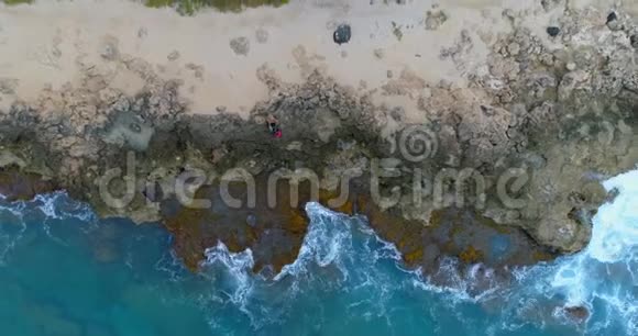 一对夫妇坐在岩石海岸4k视频的预览图