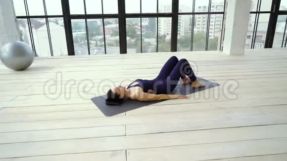 运动苗条的女孩做伸展运动腿在瑜伽垫在工作室视频的预览图