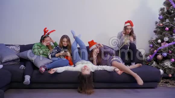 五个女孩用手机在沙发上放松视频的预览图