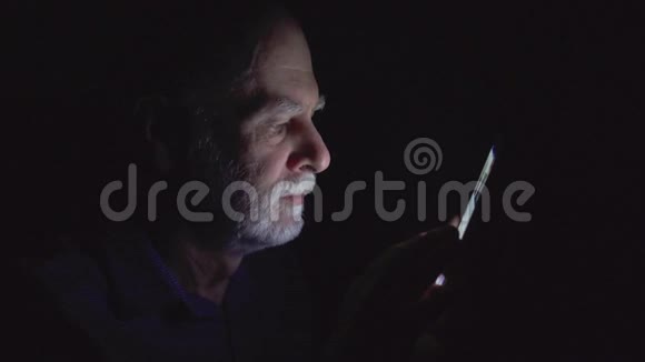 老人在家休息深夜用手机看新闻只有一张漆黑的脸视频的预览图