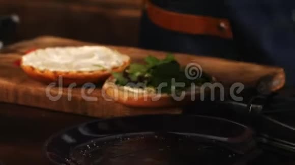 男厨师在蓝色围裙上的特写在油炸汉堡包上添加美味多汁的鸡肉库存数据视频的预览图