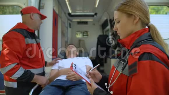 医护人员在担架上检查病人同事做记录救援队视频的预览图