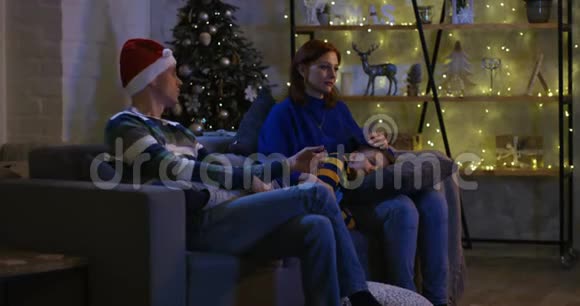 家人在圣诞夜看电视视频的预览图