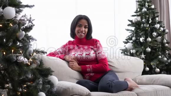 坐在圣诞树旁边沙发上的少女视频的预览图