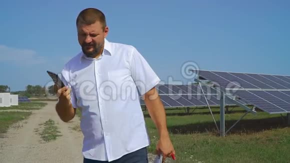 在太阳能电池板背景下打电话的人视频的预览图