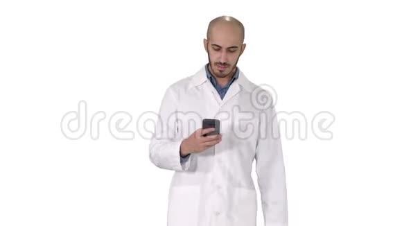 男性阿拉伯医生在白色背景下行走时在电话上发短信视频的预览图