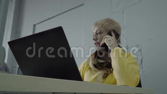 成熟的女人在办公室打电话视频的预览图
