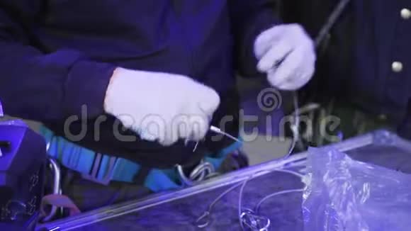 穿制服的工人和戴白手套的工人用手握有扣钩的铁丝视频的预览图