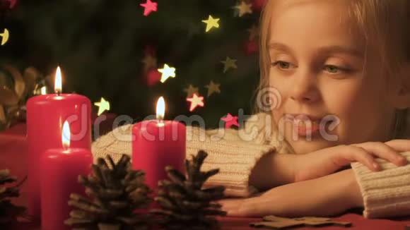 看着蜡烛燃烧的女孩快乐的童年和对圣诞节奇迹的信心视频的预览图