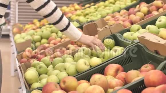 在水果蔬菜超市选择苹果的不可识别的年轻女性视频的预览图