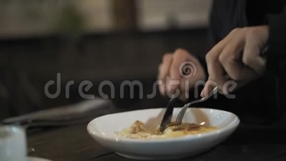 特写一个人手里拿着餐具在夜店里坐着切切片视频的预览图