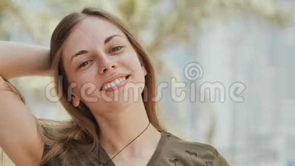 夏日里一个年轻而微笑的女孩的肖像面的特写头发乱麻视频的预览图