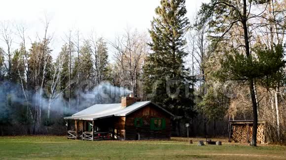 森林中一间舒适的乡村小屋的烟囱冒出壁炉的烟视频的预览图