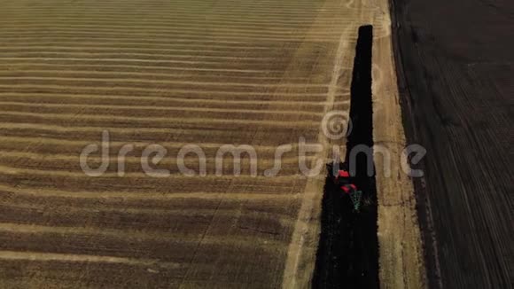 拖拉机耕田备地播种红色拖拉机空中观景农民在拖拉机上准备土地视频的预览图