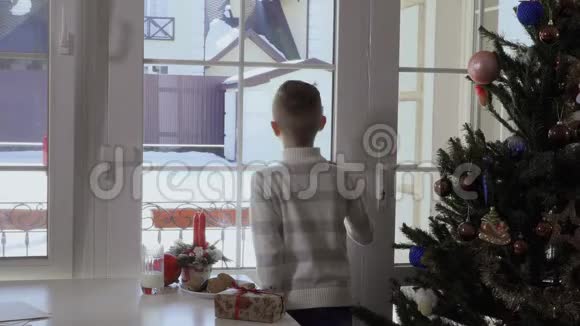 小男孩透过窗户看到圣诞老人来了视频的预览图
