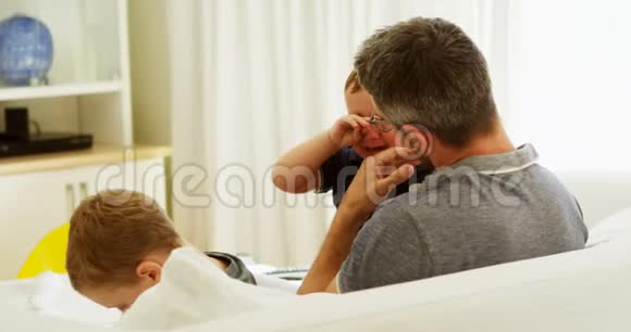 父亲在沙发上安慰哭泣的孩子视频的预览图