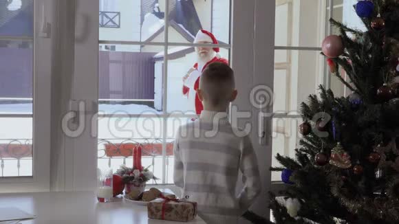 小男孩透过窗户看着圣诞老人来到房子里逃跑了视频的预览图