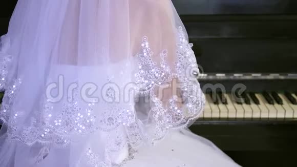 穿白色连衣裙的女孩弹钢琴新娘在钢琴上演奏一首音乐音乐生意视频的预览图