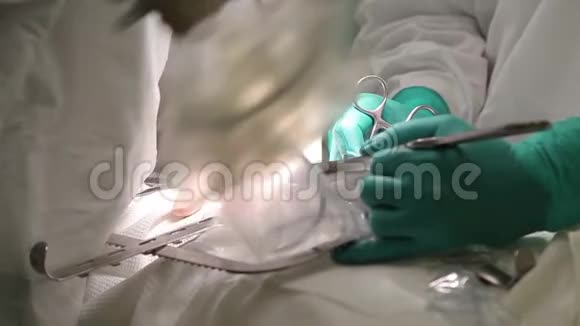 特写镜头两名穿防护服的医生使用消毒设备进行肿瘤手术视频的预览图