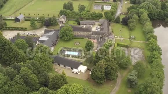 在多云的夏季欧洲灰色的夏季住宅和带有游泳池的地块被绿树环绕视频的预览图