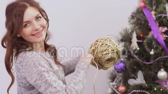 圣诞树旁有一根金线的年轻女子视频的预览图