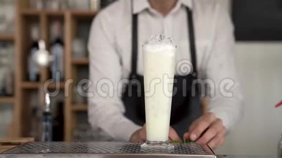 一位英俊的年轻酒保的特写双手完成了在酒吧柜台做一杯皮纳科拉达鸡尾酒视频的预览图