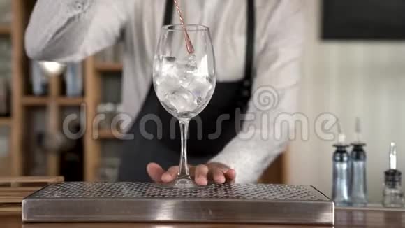 调酒师把冰块放进杯子里视频的预览图