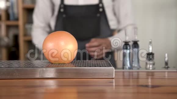 酒保的双手特写切酒吧柜台上的柚子视频的预览图