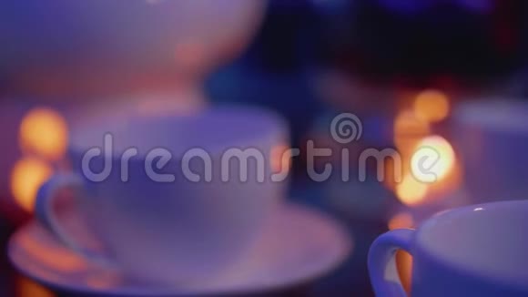 将焦点从茶杯转移到茶壶上茶壶下面有蜡烛以便在咖啡桌上加热视频的预览图
