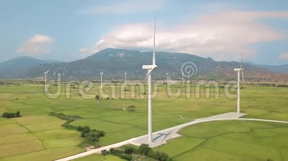 风力涡轮机产生清洁的可再生能源鸟瞰图蓝色绿色农业领域的风车涡轮机视频的预览图