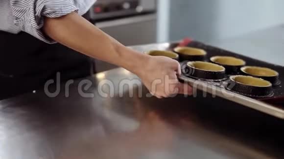 厨房糕点的概念糖果师用六种形式的生酒石托盘将其放入烤箱现代设计视频的预览图