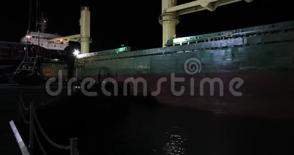 夜泊货船至煤炭码头码头码头港口工人安装梯子取系泊线视频的预览图