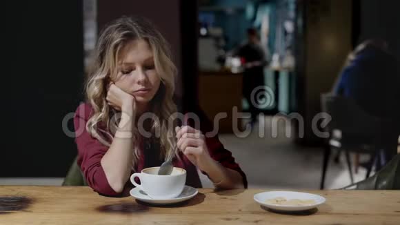 可怜的卷发少女在咖啡馆喝咖啡想着视频的预览图