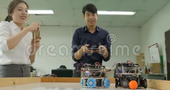 两个电子工程师编程和控制机器人踢足球视频的预览图