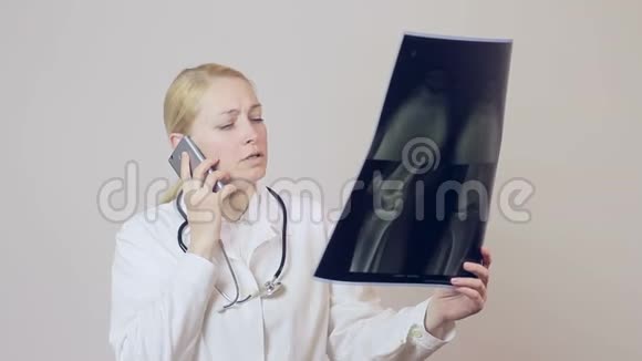 女医生打电话检查膝盖的X光图像视频的预览图