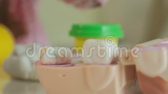 一个年轻的女人和一个女孩用塑料制成牙齿一个女孩把她的牙齿插入入牙的下巴在里面玩视频的预览图