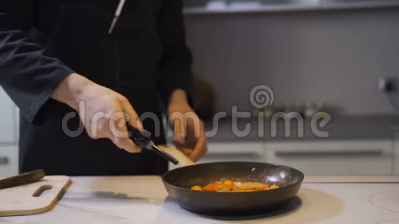 厨师在商业厨房的煤气滚刀上用燃烧的锅煎食物视频的预览图