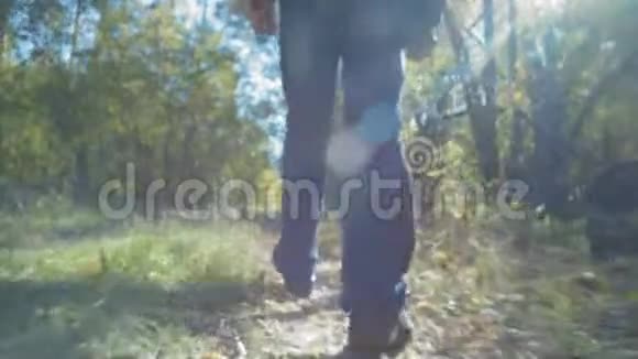 后景下面一个人的脚在森林的道路上行走视频的预览图